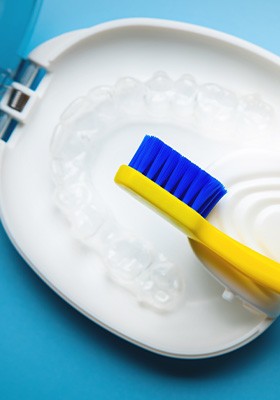 Transparent aligners in a case next to a toothbrush