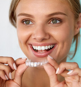 Patient in Jacksonville putting their Invisalign aligner in